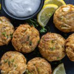 Air Fryer Crab Cakes on a tray with sauce.