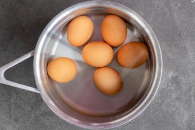 Eggs in a pot with water.