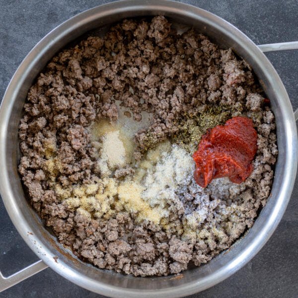 Cooked ground beef with seasoning and tomato paste.