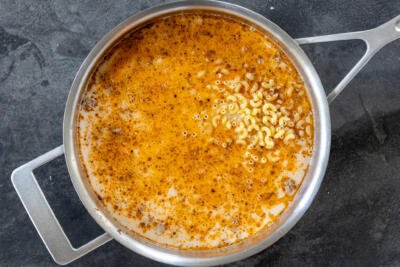 Milk, broth and pasta in a pan with beef.
