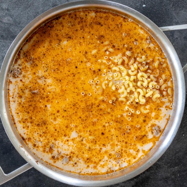 Milk, broth and pasta in a pan with beef.