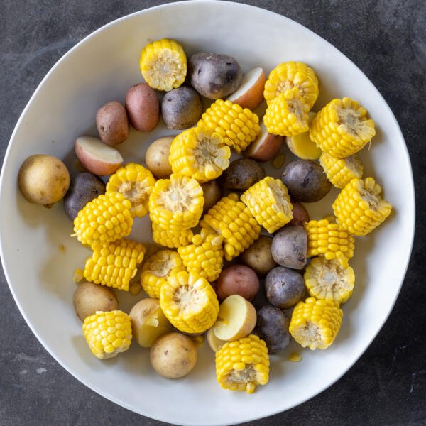 Cooked corn and potatoes in a bowl.