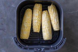 Caron on a cob in an air fryer basket.