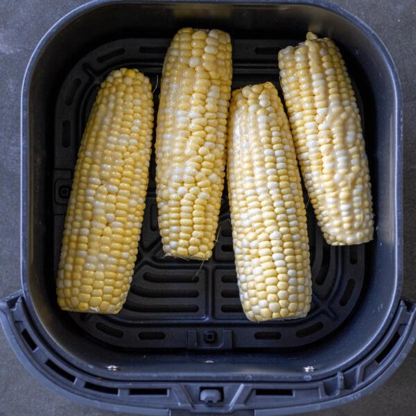 Caron on a cob in an air fryer basket.