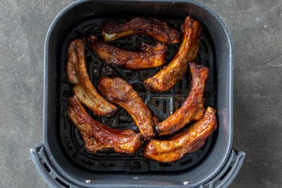 BBQ covered ribs in an air fryer baskeet.
