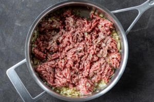 Meat added to the pan with onions.