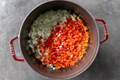 Peppers and onions frying in a pan.