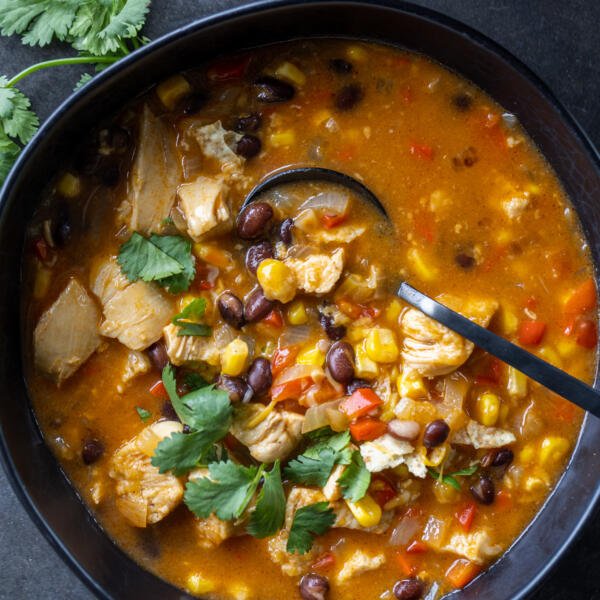 Chicken Enchilada Soup in a bowl with herbs.