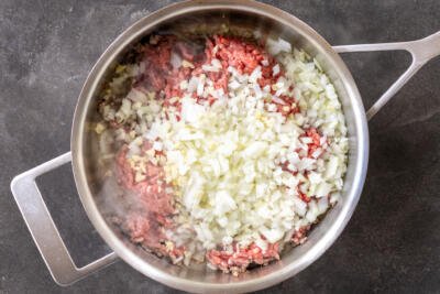 Ground beef, onions in a frying pan.