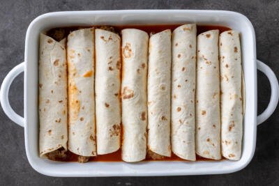 Rolled up tortillas with ground beef enchilada sauce.