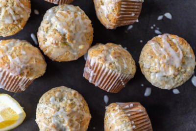 Baked Lemon Poppy Seed Muffins with glaze and lemon slices.