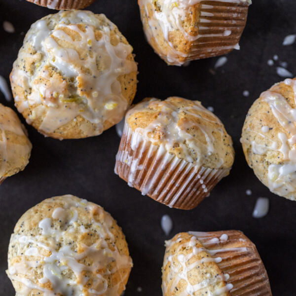 Baked Lemon Poppy Seed Muffins with glaze and lemon slices.