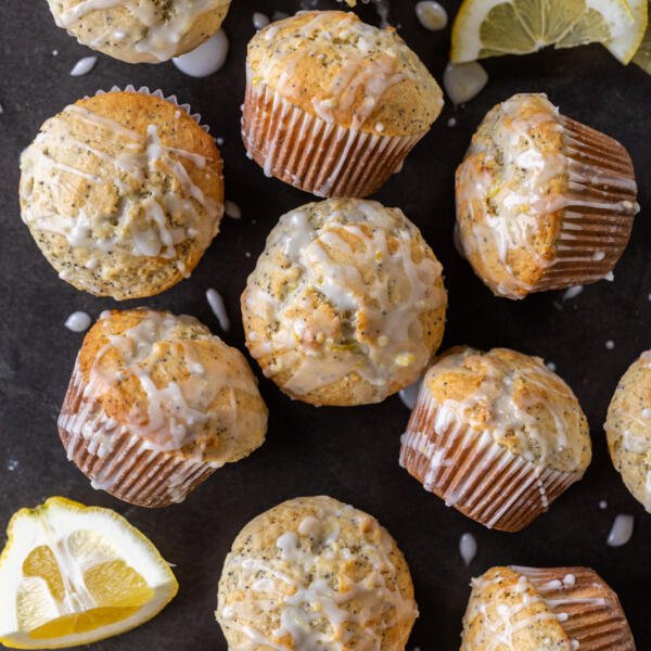 Baked Lemon Poppy Seed Muffins with glaze and lemon slices.