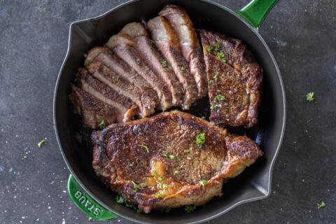 One piece sliced steak in a pan.