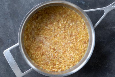 Orzo simmering in a pan.