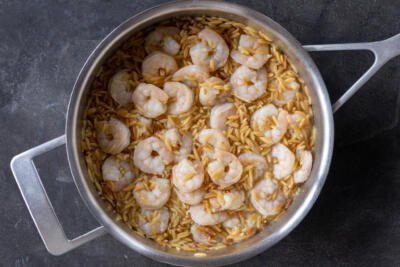Shrimp added to th epan with orzo.