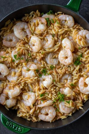 Shrimp Orzo in a pan with herbs.