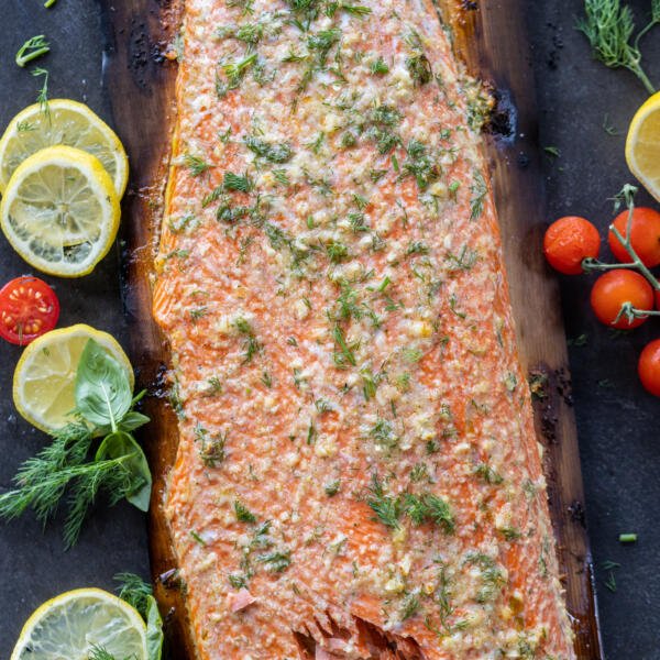 Grilled Cedar Plank Salmon with citrus and veggies next to it.