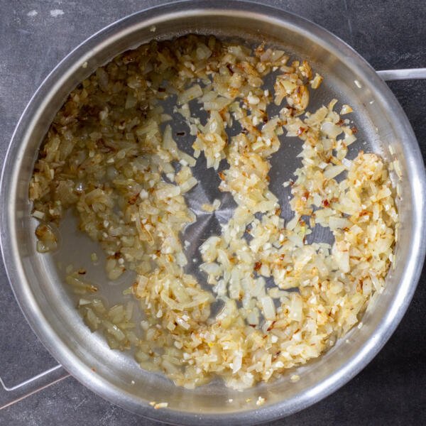 Cooked onion, garlic and vodka in a pan.