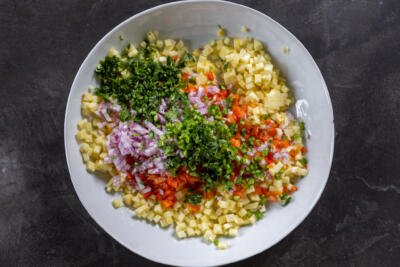 Chopped veggies with herbs in a bowl.