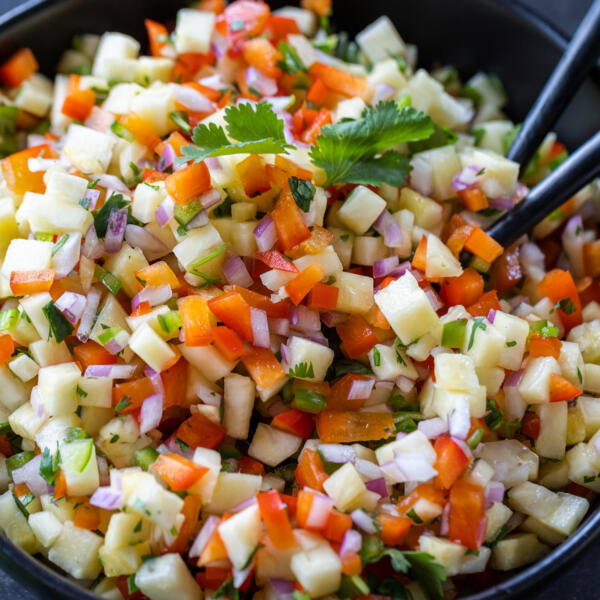 Fresh Pineapple Salsa in a bowl with a serving spoon.