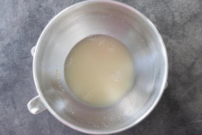 Liquid, yeast and sugar in a mixing bowl.