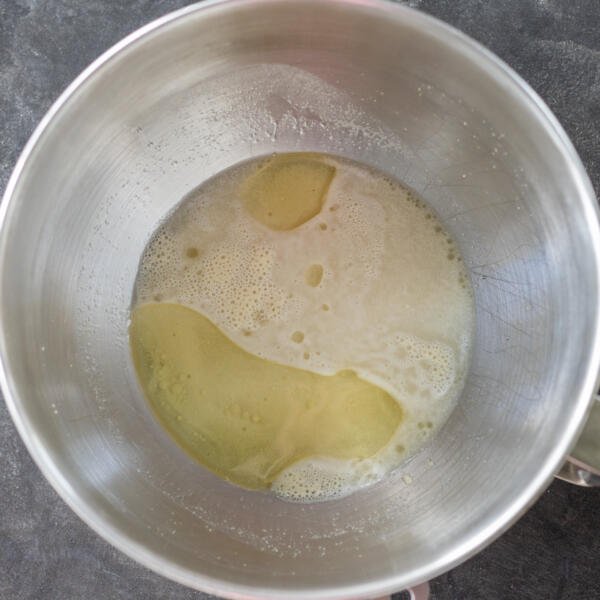 Oil and salt added to the liquids in a mixing bowl.
