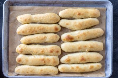 Baked Olive Garden Breadsticks on a sheet with butter garlic.