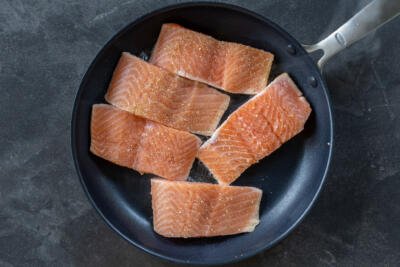 Salmon frying in a pan.