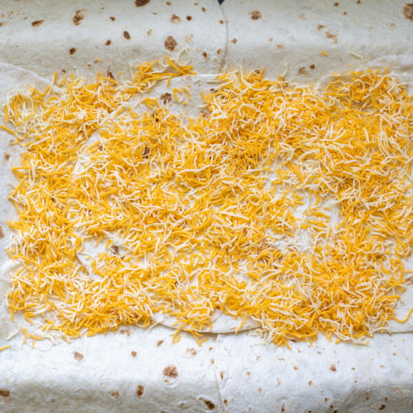 Tortillas on a sheet pan with cheese.
