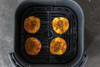 Air fryer baskets with peaches.