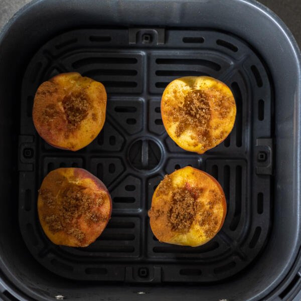 Air fryer baskets with peaches.