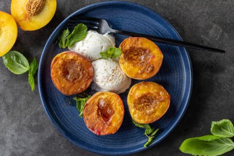 Air Fryer Peaches on a plate with ice cream and mint.