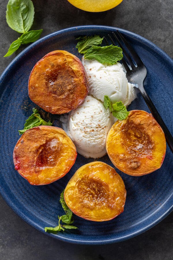 Air Fryer Peaches on a plate with ice cream.
