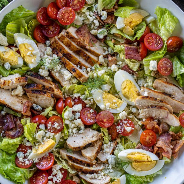 Cobb Salad in a bowl with veggies around.