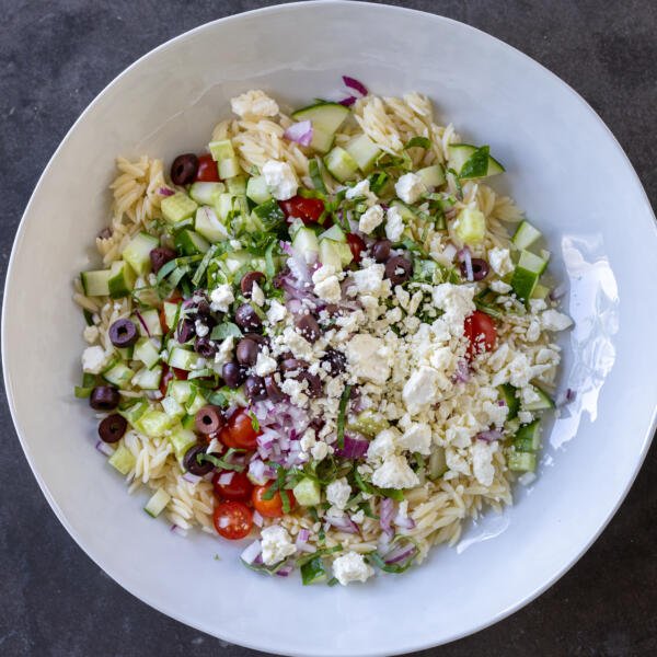 Greek Orzo Salad with Feta with dressing added to it.