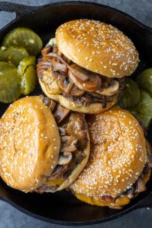 Messy burgers in a serving dish.