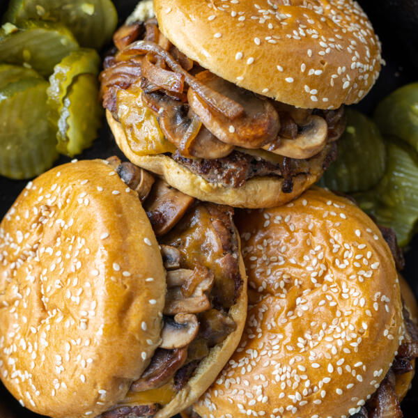 Messy burgers in a serving dish.