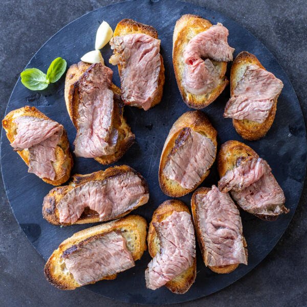 Bruschetta with slices of steak.