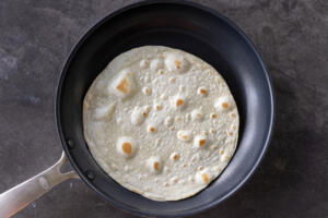 Tortilla cooking on a pan.