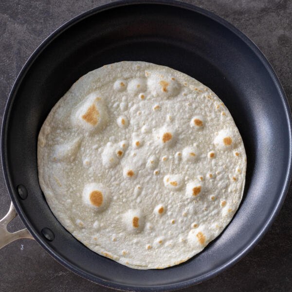 Tortilla cooking on a pan.