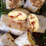 Bacon Egg And Cheese Burrito cut open on a pan.