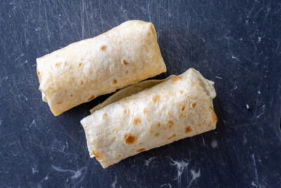 Bacon Egg And Cheese Burritos on a cutting board.