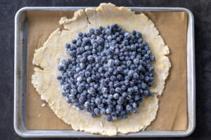 Blueberries on galette crust on a baking sheet.