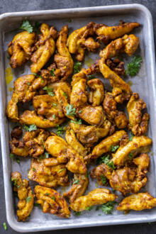 Sheet Pan Chicken Shawarma on a sheet pan with herbs.