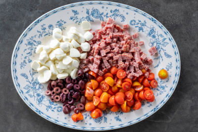 Cut up salami, olives, tomatoes and mozzarella.