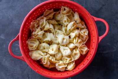 Cooked Tortellini in a colander.
