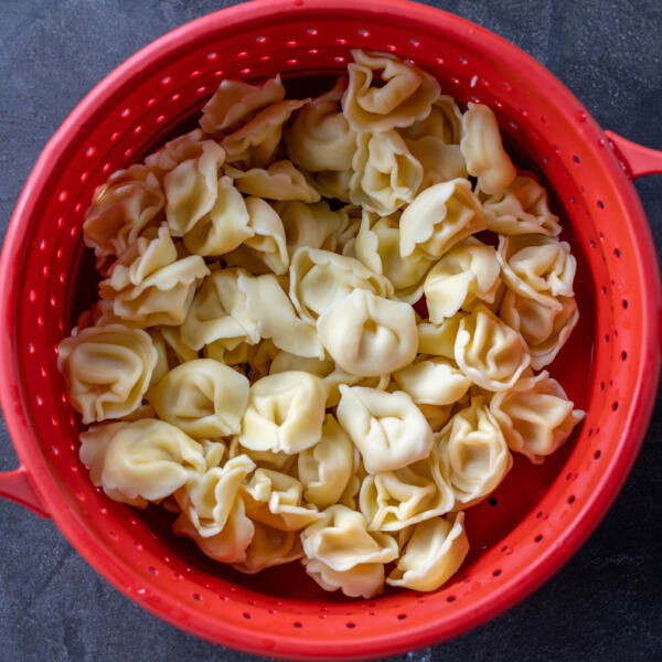 Cooked Tortellini in a colander.