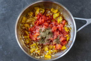 Tomatos added to bell pepper and onion and seaosning.