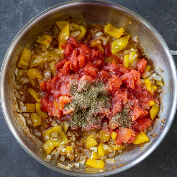 Tomatos added to bell pepper and onion and seaosning.